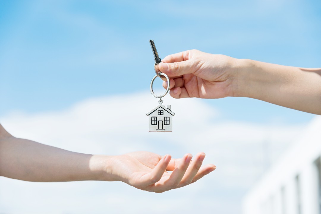Handing over a key with house keychain