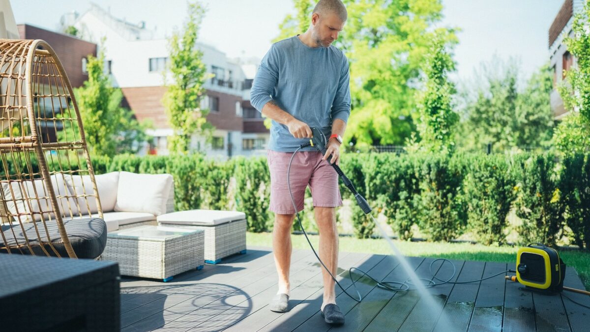 Man cleaning his veranda with high pressure washer
